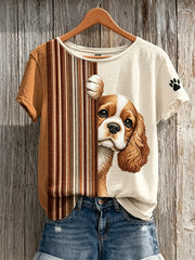 T-shirt à manches courtes pour femme, motif color-block avec un épagneul royal de Charles qui fait coucou et des empreintes de pattes